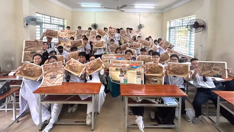 Los estudiantes con la publicación informativa especial de Nhan Dan.