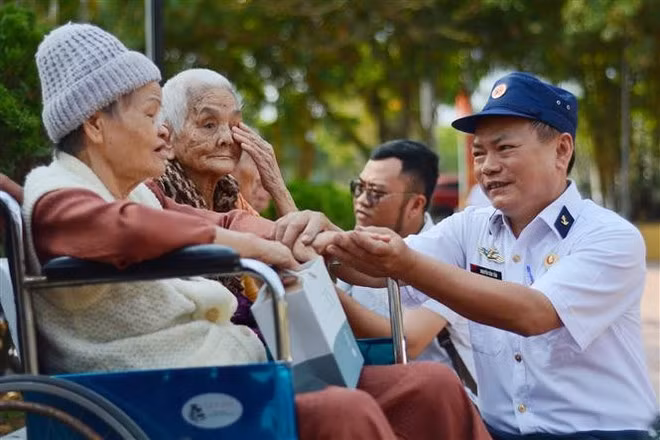 Veteranos de guerra conversan con familiares de soldados caídos en la batalla de Gac Ma. (Foto: VNA)