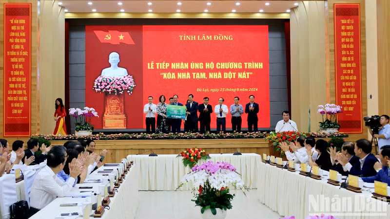 El premier Pham Minh Chinh, quien también es presidente del Consejo Central de Emulación y Recompensa, presencia la entrega simbólica de asistencia al programa por parte de las empresas y organizaciones.