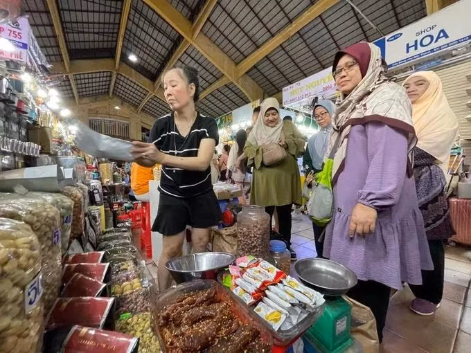 Turistas musulmanes visitan y compran especialidades vietnamitas en el mercado Ben Thanh, en Ciudad Ho Chi Minh. (Foto: sggp.org.vn)
