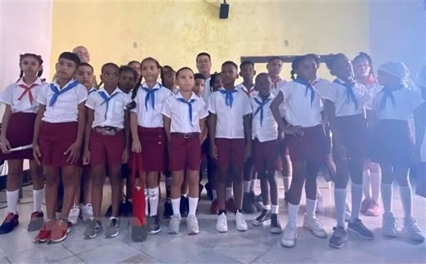 El embajador de Vietnam en La Habana, Le Thanh Tung, y los niños cubanos. (Fotografía: VNA)