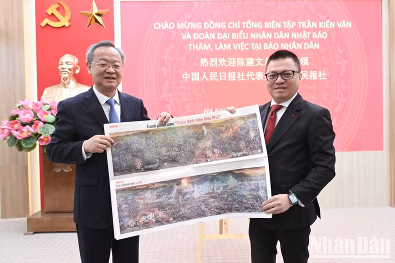 Quoc Minh entrega a Chen Jianwen el suplemento Campaña de Dien Bien Phu de la publicación escrita de Nhan Dan.