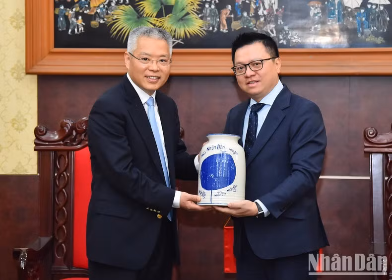 Quoc Minh entrega un obsequio al visitante chino.