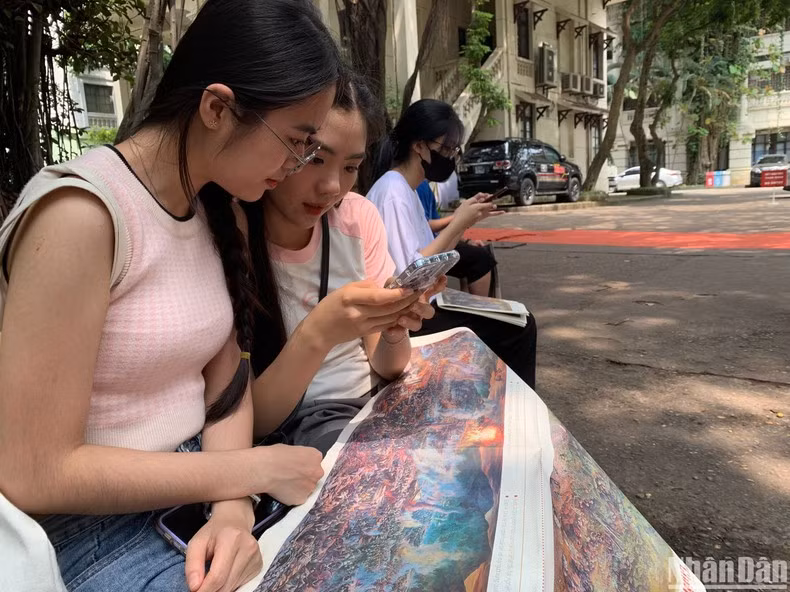 Dam Hieu Phuong y Nguyen Lan Anh, residentes en Thanh Tri, Hanói, quedan asombradas por la vívida información visualizada virtualmente.