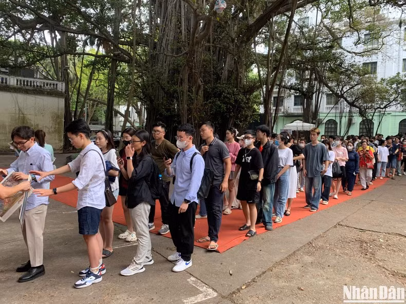 Los visitantes esperan en largas colas para recibir la versión en papel de dicha pintura.