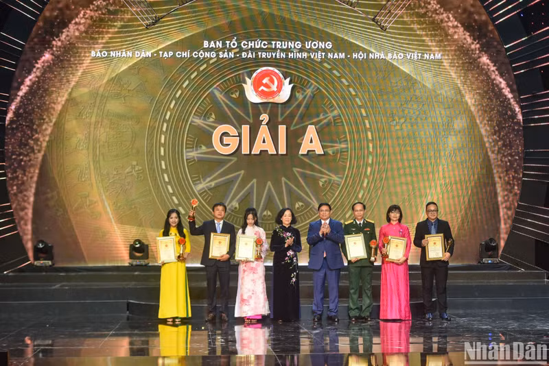 El primer ministro Pham Minh Chinh y la miembro permanente del Secretariado del Comité Central del PCV y jefa de su Comisión de Organización, Truong Thi Mai, otorgan el premio A a los ganadores.
