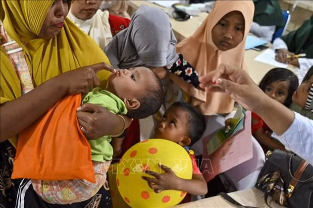 Niños tomando vitaminas en Indonesia (Fotografía: AFP)