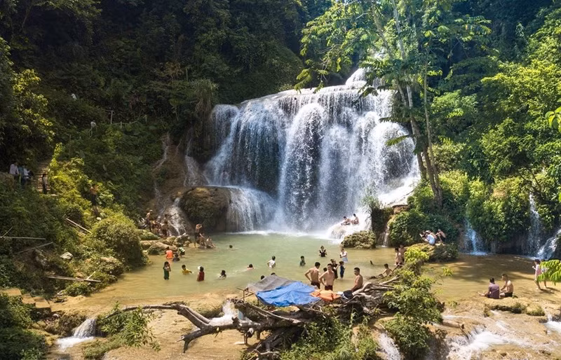 Los turistas vienen a visitar y divertirse justo al pie de la catarata Mu.