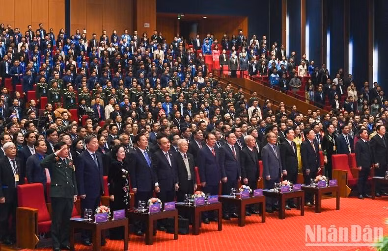 Los dirigentes y delegados saludan a la bandera nacional.