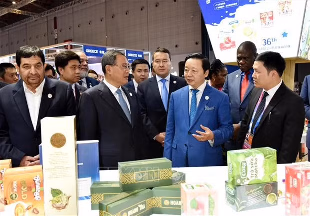 El viceprimer ministro de Vietnam Tran Hong Ha presenta al primer ministro de China, Li Qiang, sobre los productos vietnamitas en el evento.