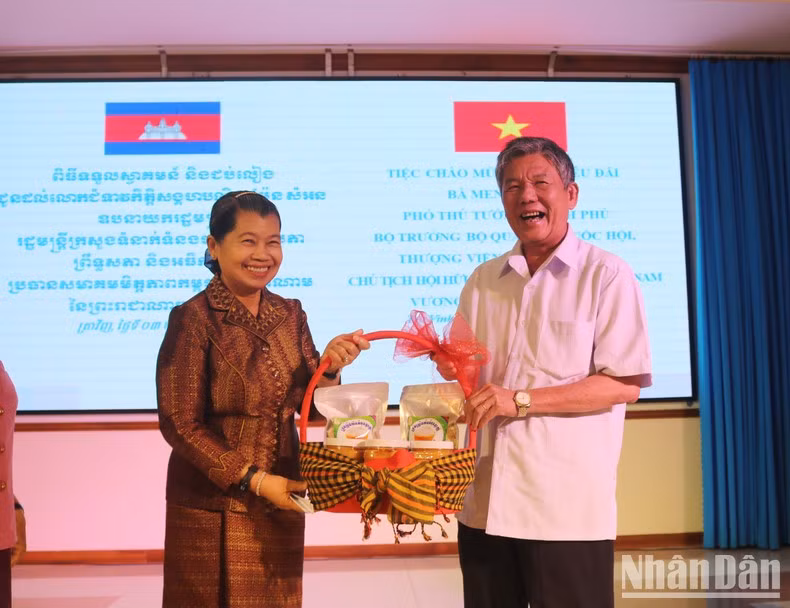 Men Sam An, viceprimera ministra, titular de Relaciones de la Asamblea Nacional y del Senado, Inspectora del Reino de Camboya y presidenta de la Asociación de Amistad Camboya-Vietnam entrega un regalo de Tet a Ngo Chi Cuong, secretario del Comité del Partido Comunista de Vietnam en Tra Vinh.