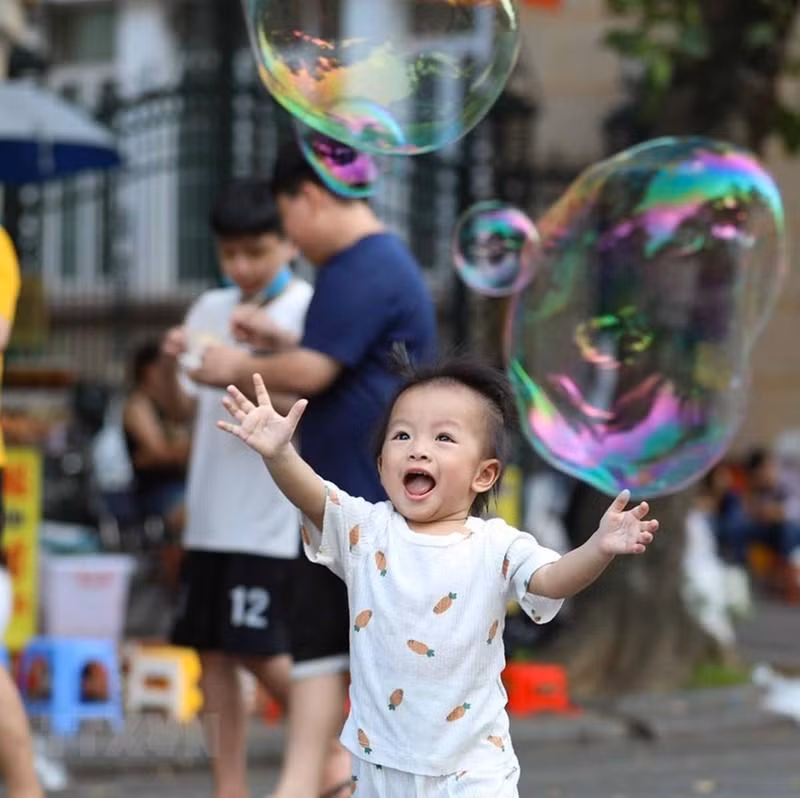 Los niños hacen pompas en el espacio peatonal del lago Hoan Kiem.