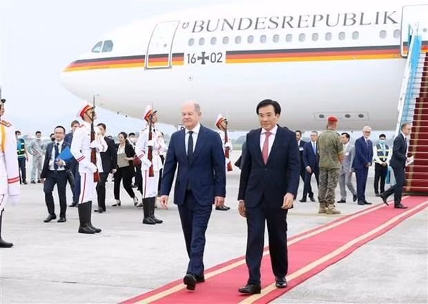 El canciller alemán Olaf Scholz (I) es recibido en el Aeropuerto Internacional Noi Bai en Hanói. (Fotografía: VNA)