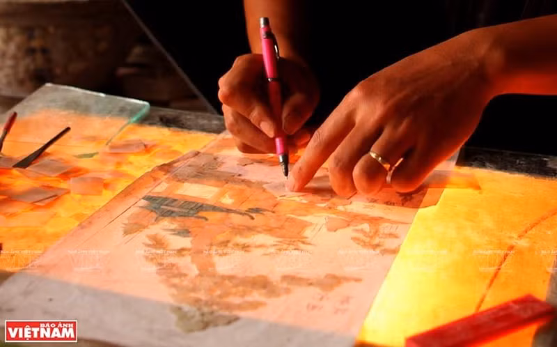 Los creadores dibujan prototipos en papel antes de tallar en madera. (Foto: VNA) Los creadores dibujan prototipos en papel antes de tallar en madera. (Foto: VNA)