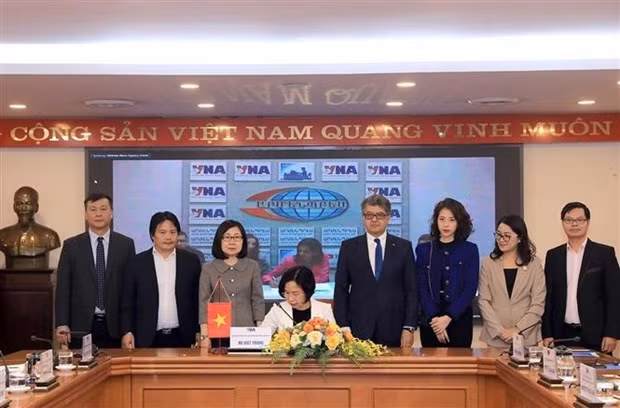La directora general de la VNA, Vu Viet Trang (sentada), firma el acuerdo de cooperación con la agencia de noticias Armenpress. (Fotografía: VNA)