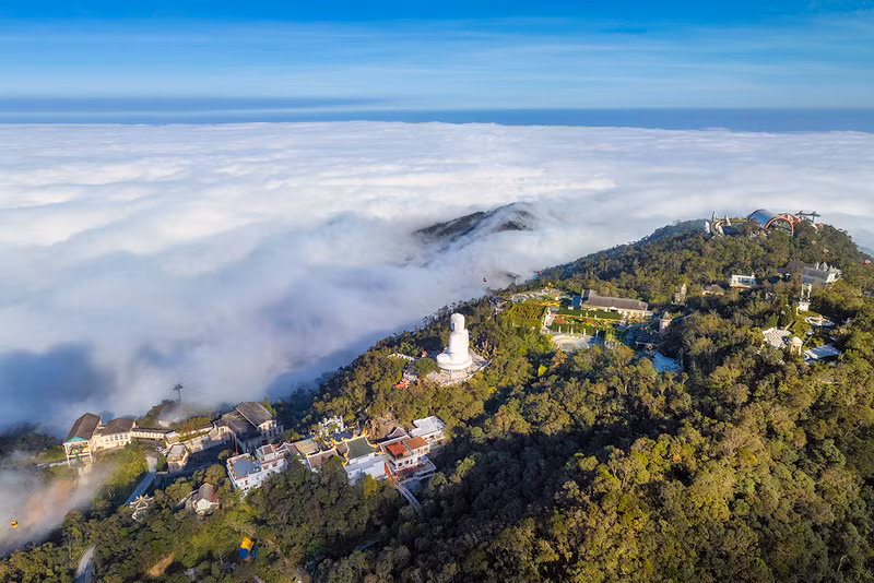 Nubes blancas cubren la cima de Ba Na, extendiéndose hasta el horizonte.