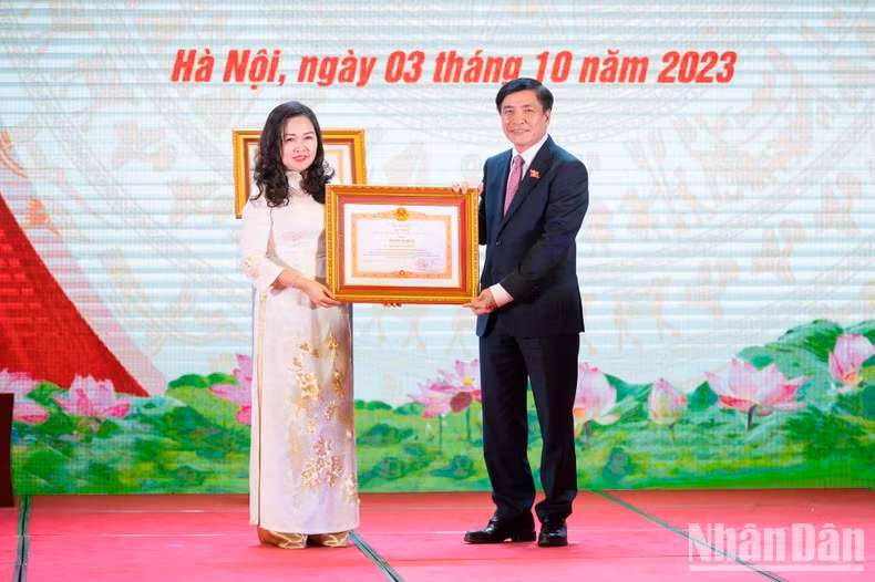 El secretario general y jefe de la Oficina del Parlamento, Bui Van Cuong, entrega el certificado de mérito del primer ministro a Thanh Huyen.