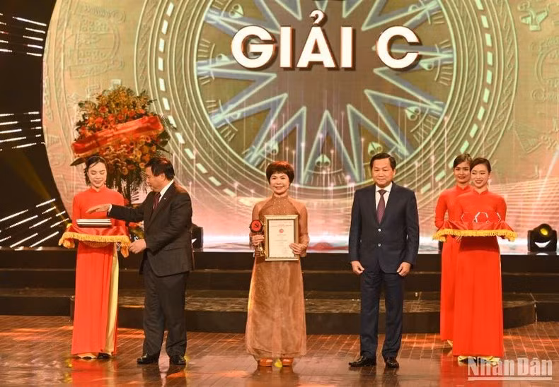 El director de la Academia Nacional de Política Ho Chi Minh, Nguyen Xuan Thang, y el viceprimer ministro, Le Minh Khai, entregan los Premios C a la autora Tieu Phuong del periódico Nan Dan. El director de la Academia Nacional de Política Ho Chi Minh, Nguyen Xuan Thang, y el viceprimer ministro, Le Minh Khai, entregan los Premios C a la autora Tieu Phuong del periódico Nan Dan.