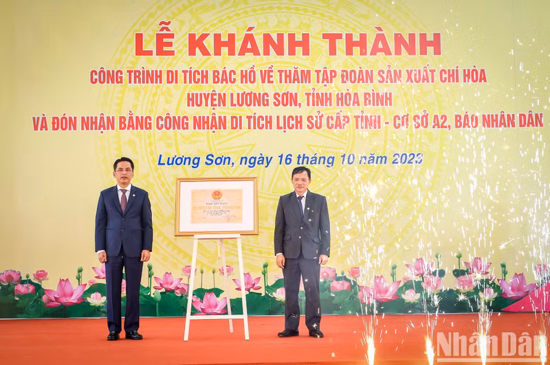 Bui Van Khanh (izquierda), vicesecretario del Comité del Partido y presidente del Comité Popular de Hoa Binh, entrega el Certificado de reconocimiento como Reliquia Histórico-Cultural Provincial a la Base A2 del periódico Nhan Dan.