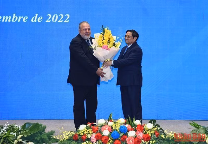 Minh Chinh entrega flores para felicitar a Manuel Marrero Cruz.