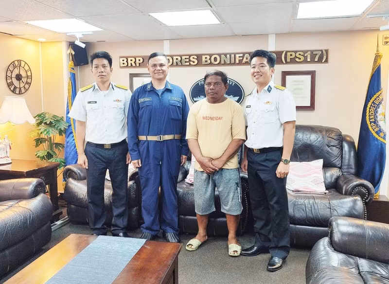 El oficial del Alto Mando de la Región Naval 4 de Vietnam (camisa blanca), el pescador filipino (camisa amarilla) y el personal de la patrullera filipina. (Foto: VNA)