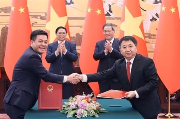 El primer ministro de Vietnam,Pham Minh Chinh, y su homólogo chino, Li Qiang, presencian la firma de acuerdos de cooperación entre ambas partes (Fotografía: VNA)