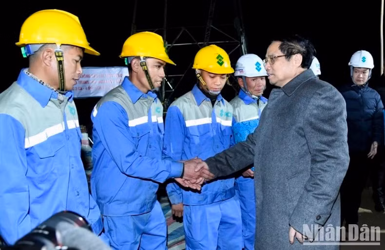 Minh Chinh alienta a los trabajadores en el sitio de construcción.