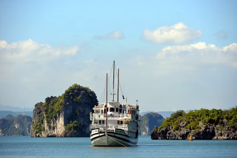 Los turistas disfrutan paisajes hermosos de la Bahía de Ha Long al viajar en cruceros.