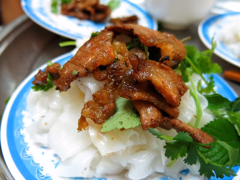 Los rollitos están hechos principalmente de harina de arroz, se sirven con hierbas, cebollas fritas con salsa de pescado y jamón vietnamita, o carne a la parrilla como Banh cuon Phu Ly (Ha Nam).