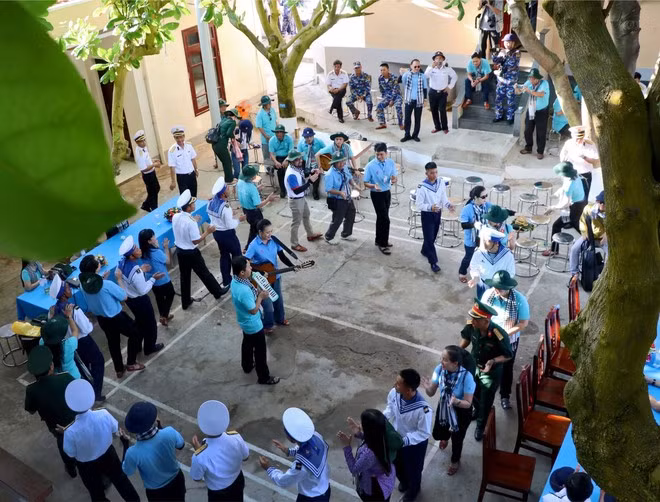 Oficiales y soldados de la isla de An Bang cantan junto con visitados.