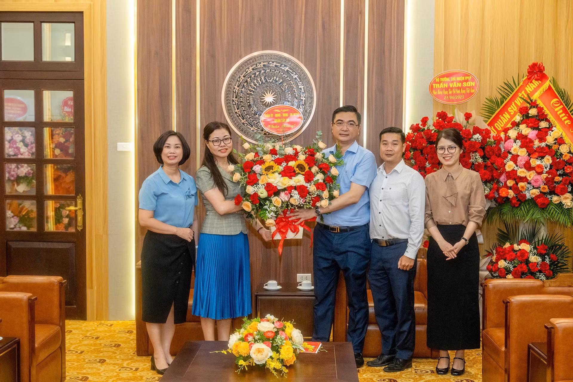 Representantes del Comité del Partido en el distrito de Tay Ho, el Consejo Popular y el Comité Popular de esa localidad entregan flores de felicitación al periódico Nhan Dan.