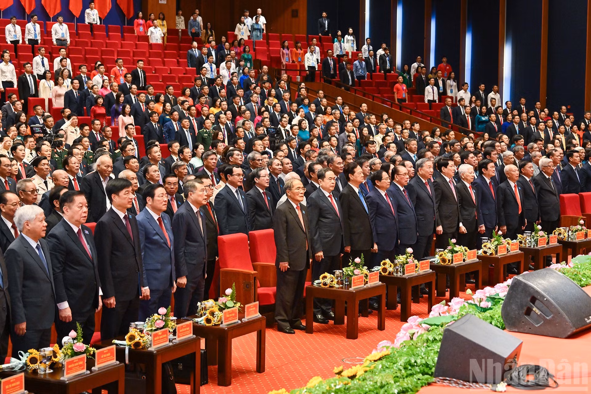 Dirigentes y exdirigentes del Partido y del Estado, junto con otros delegados a la asamblea, efectúan el acto de saludo a la bandera.