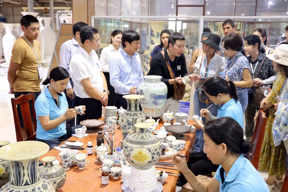 Los visitantes muestran interés en el proceso artesanal de la cerámica de Chu Dau.