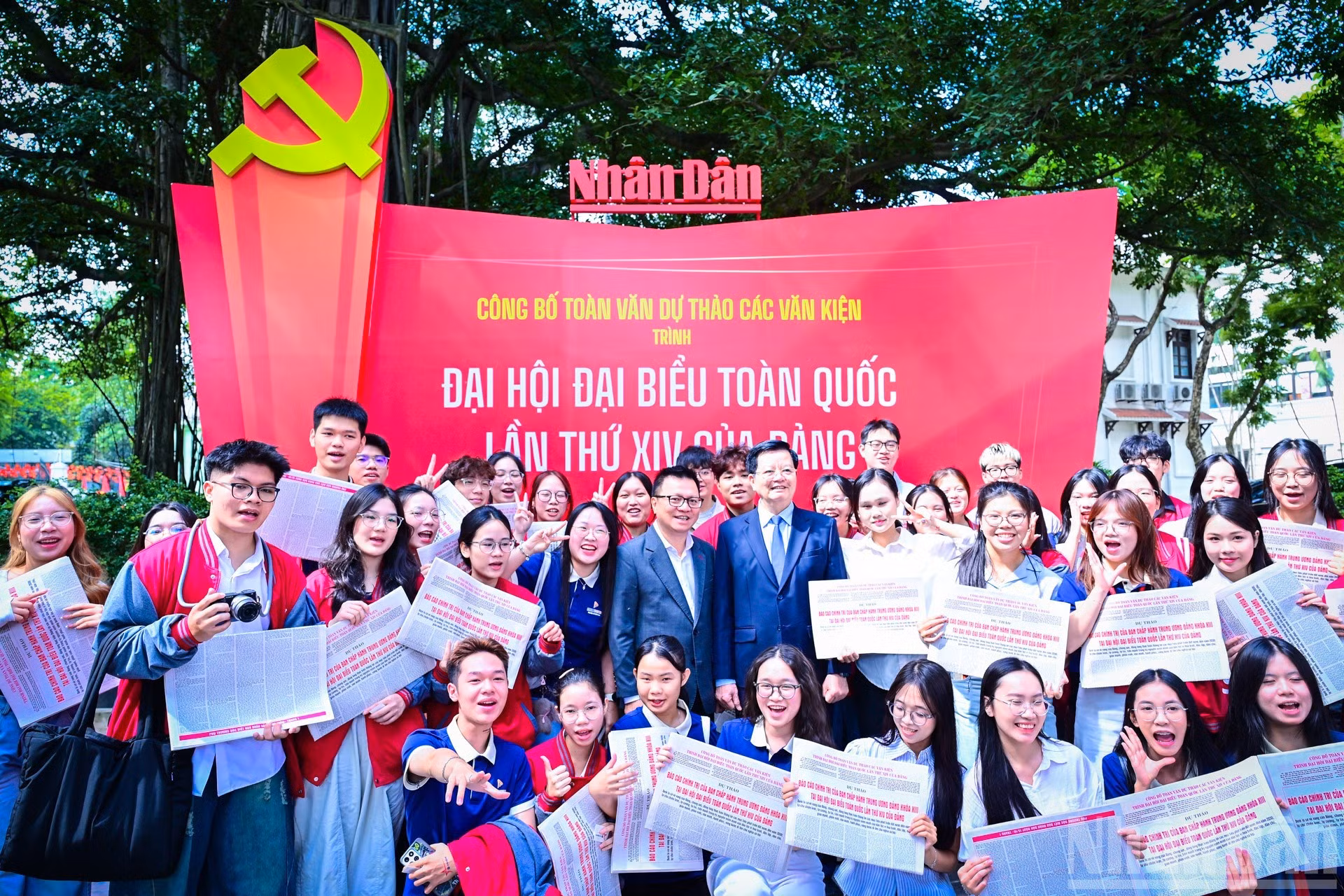 Dirigentes participantes en el conversatorio recorren la exposición en la sede de Nhan Dan y se toman fotos con lectores jóvenes.