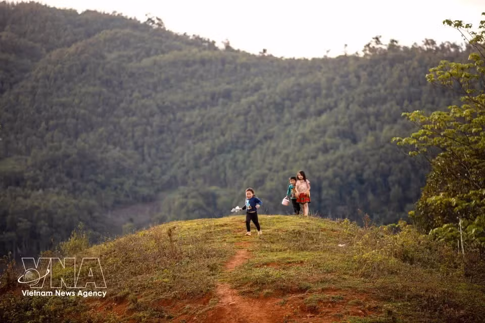 Niños de Lang Sang juegan a diario en los senderos de la aldea en medio del tranquilo paisaje de montañas y colinas.