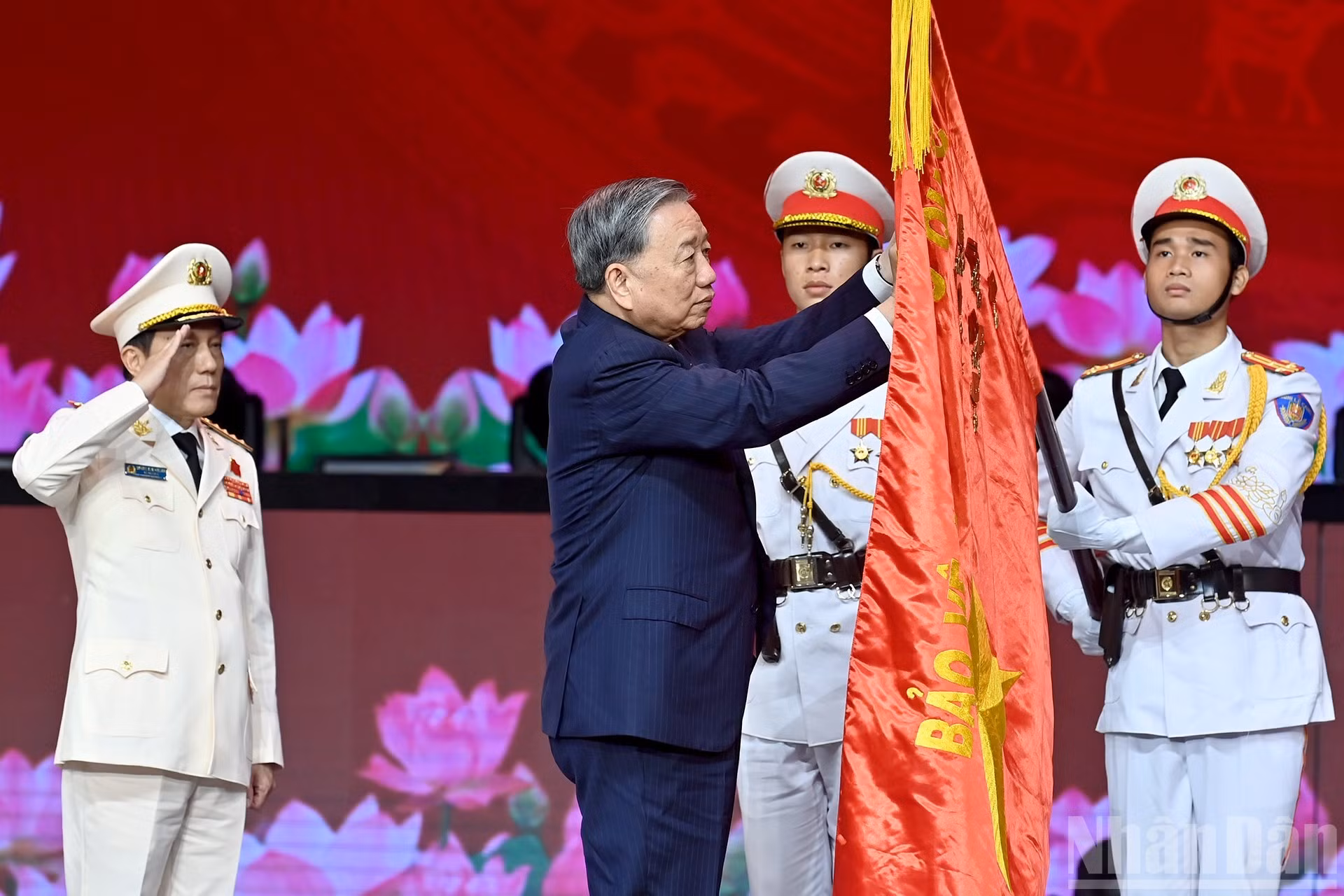 El secretario general del Partido, To Lam, pincha la Orden de la Estrella Dorada en la bandera tradicional de la fuerza de Seguridad Pública Popular.