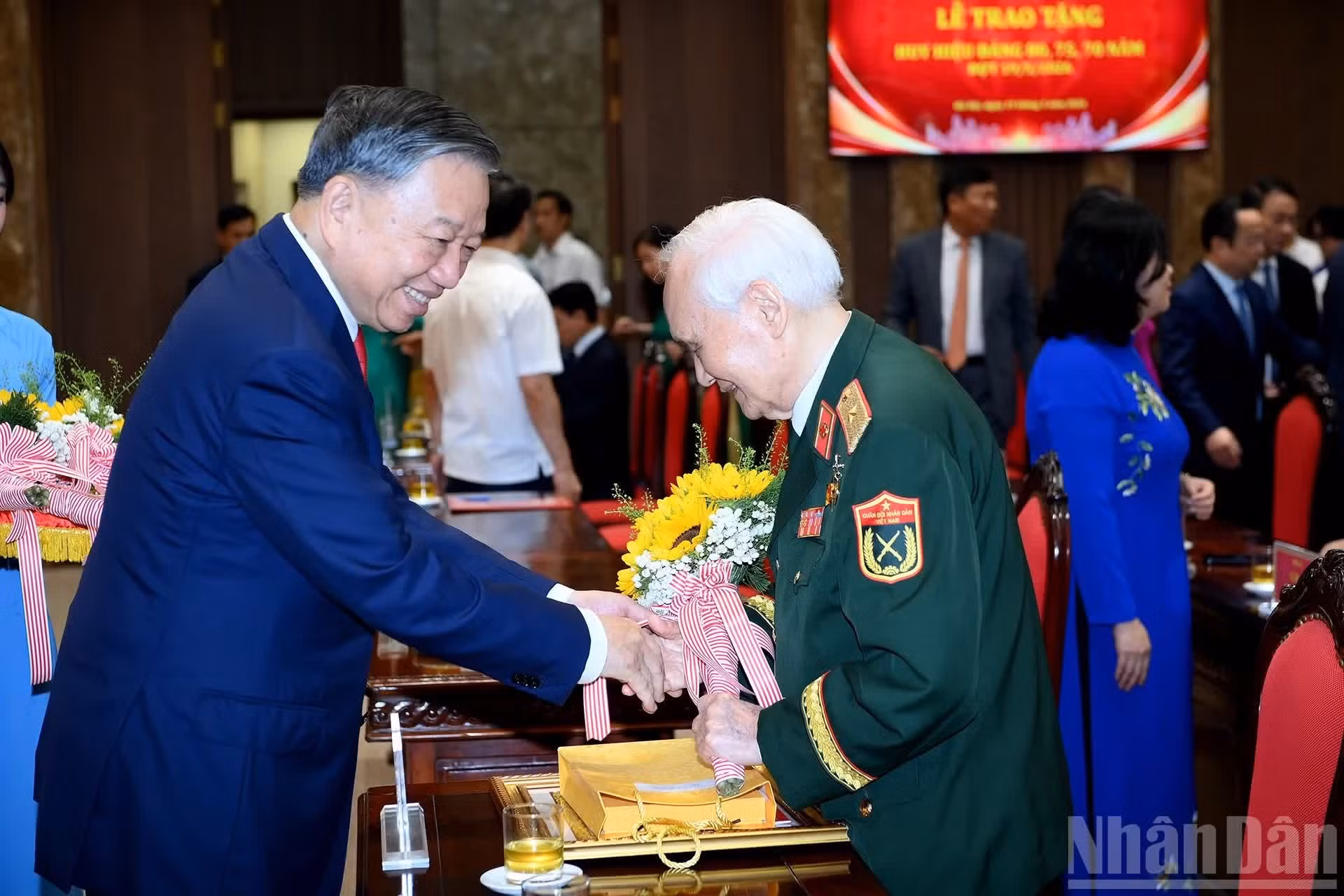 To Lam entrega flores de felicitación a un militante merecedor.