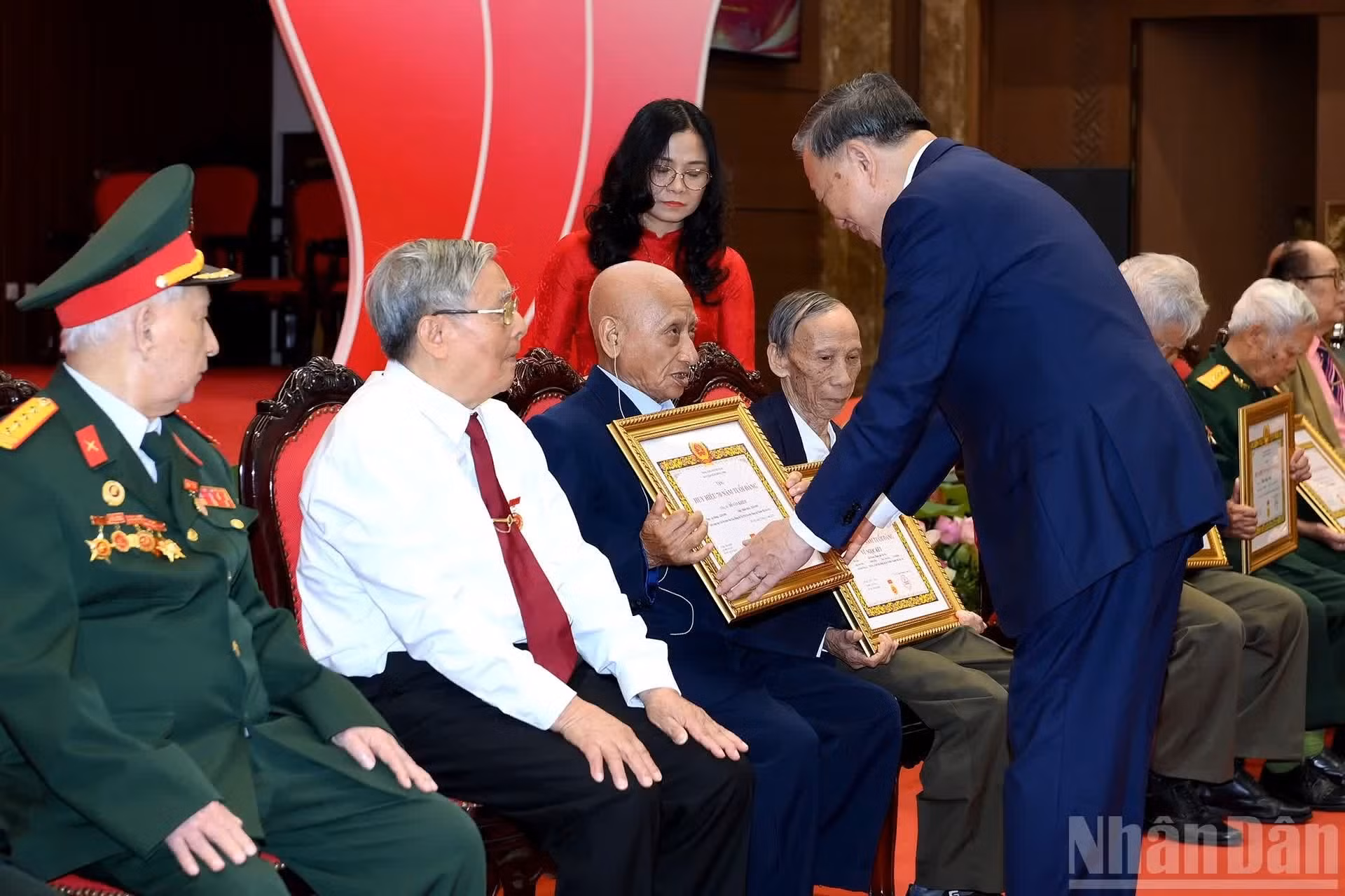 To Lam entrega certificados a militantes que cumplen 80 años de membresía.