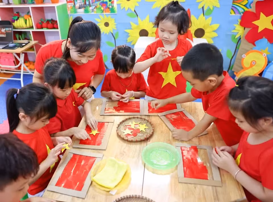 Los niños de preescolar recortan y pegan con cuidado y dedicación para formar una bandera nacional brillante.