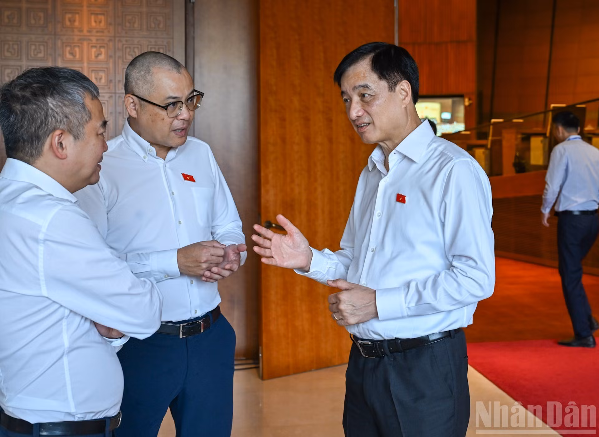 El jefe de la Comisión de Organización del Comité Central del Partido, Nguyen Duy Ngoc (primero a la derecha), charla con diputados al margen de la sesión.