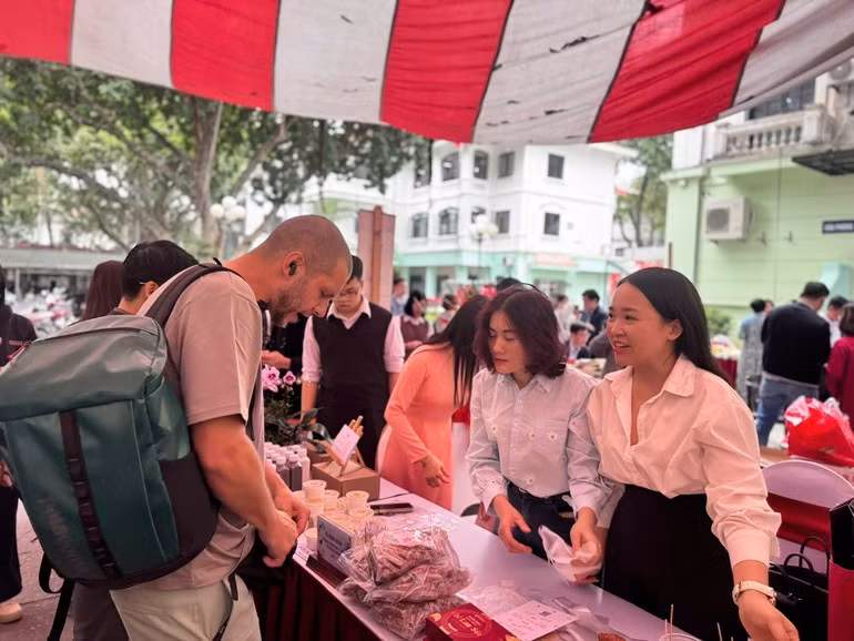 Turistas extranjeros muestran interés por los productos presentados en la feria.