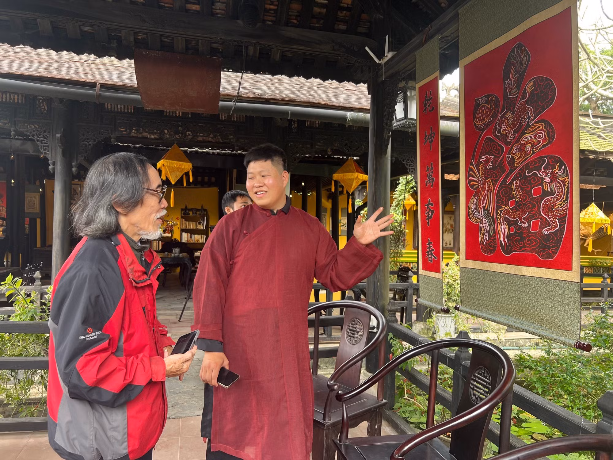 El artesano Nguyen Cong Dat conversa con Nguyen Phuoc Vinh Khanh, experto en cultura y restauración de reliquias.