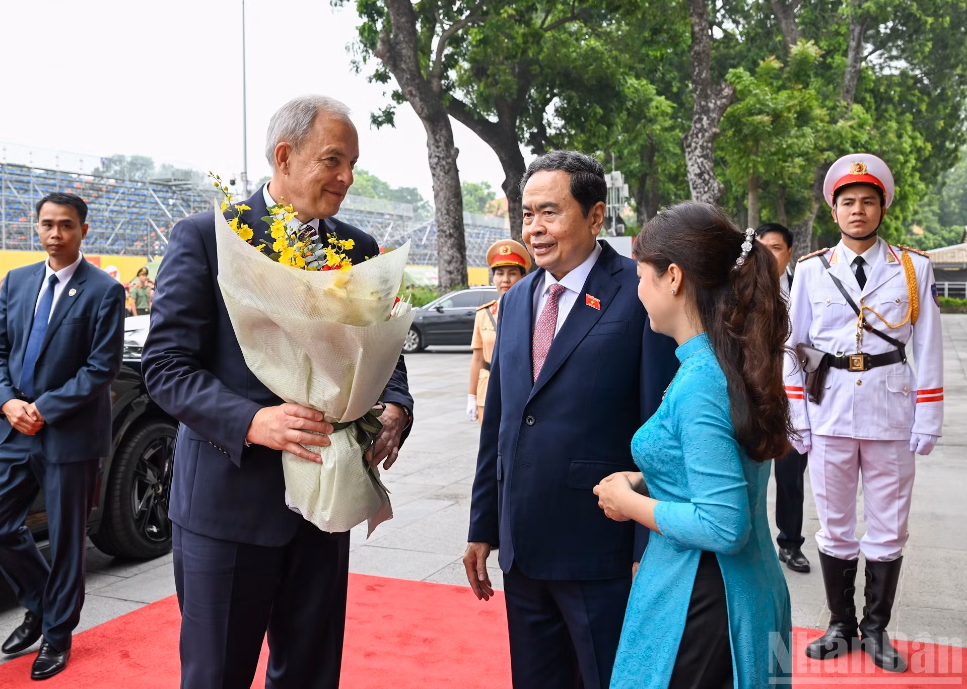Una empleada de la Oficina Parlamentaria de Vietnam otorga flores de bienvenida al dirigente bielorruso.