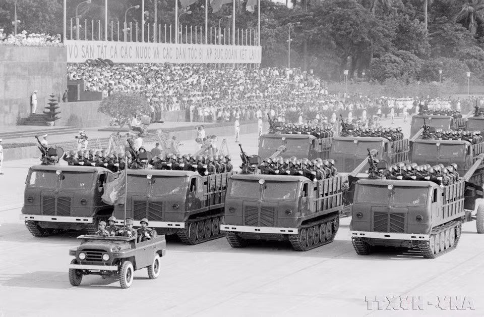 Unidades del Ejército Popular de Vietnam desfilan frente al escenario.