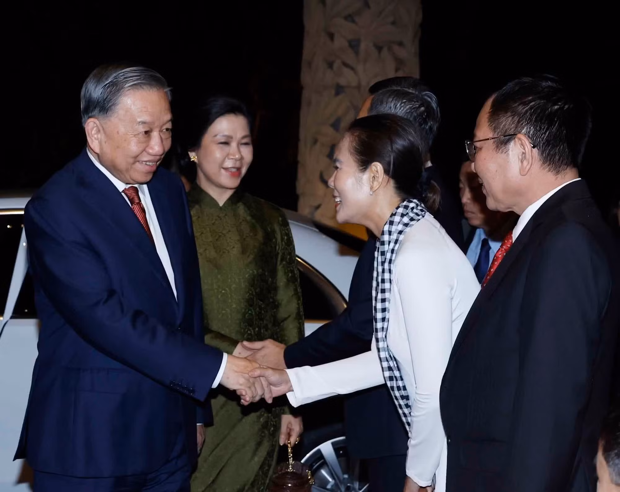Empleados de la Embajada de Vietnam y representantes de la comunidad connacional en Singapur dan la bienvenida al secretario general del Partido y presidente To Lam y su cónyuge.