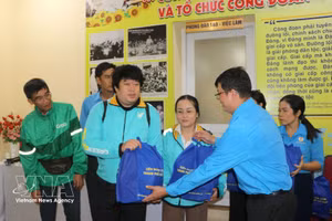 Dirigentes del Centro de Consultoría y Apoyo a los Trabajadores del Sindicato de Ciudad Ho Chi Minh entregan obsequios a conductores de plataformas digitales en situación difícil. (Foto: VNA)