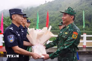 Representantes de las dos partes intercambian flores en la línea de demarcación del puente de la amistad en la frontera compartida. (Foto: VNA)