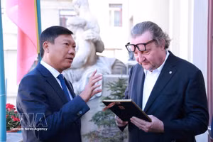 El vicepresidente del Comité Popular de Hanoi, Do Anh Tuan (izquierda), obsequia un regalo al vicealcalde de Praga, Petr Hlavacek. (Foto: VNA)
