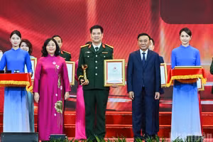 Tran Cam Tu, miembro permanente del Secretariado del Comité Central del PCV, y Bui Thi Minh Hoai, presidenta del Comité Central del Frente de la Patria de Vietnam, entregan los premios A a los autores y grupos de autores galardonados. (Foto: DUY LINH)