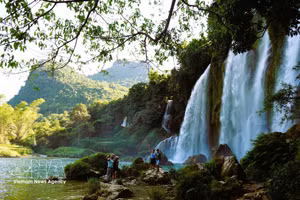 Turistas extranjeros capturan imágenes de la belleza de la cascada de Ban Gioc. (Foto: VNA)